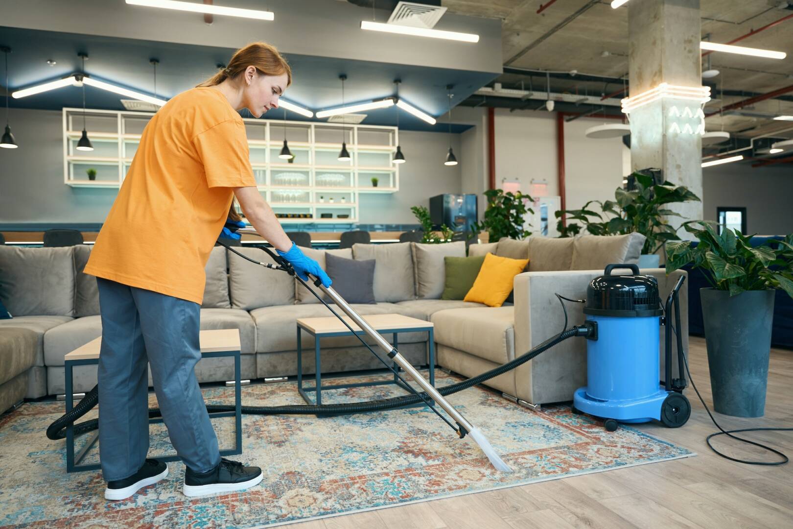 Cleaning company worker cleans a carpet in a recreation area
